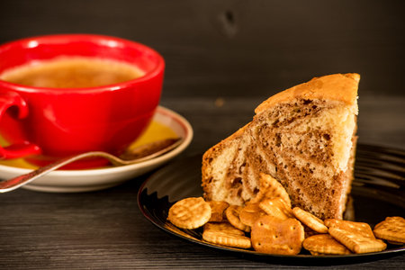 Cup of coffee and bread with crackers on black wooden tableの写真素材