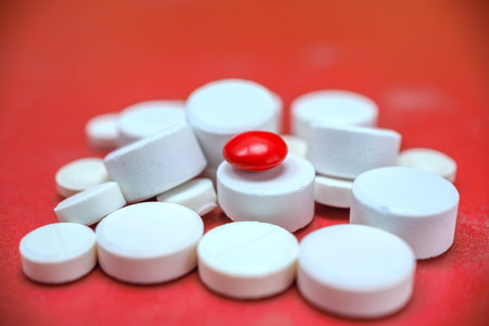 Pills and red pill on red background. Focus on foreground.の写真素材