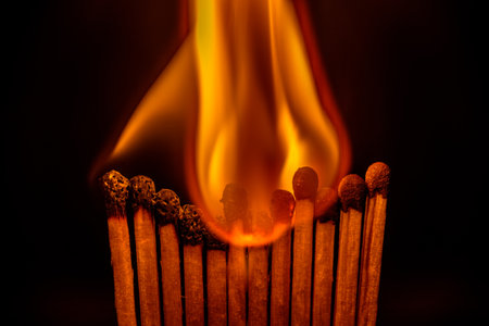 Close up of burning matchsticks on black background, fire concept.の写真素材