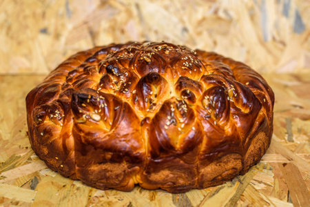Easter bread with sesame seeds on a wooden background, close-upの写真素材