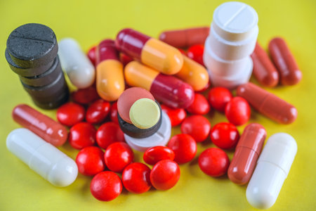 Colorful pills on yellow background. Focus on foreground, soft bokeh.の写真素材