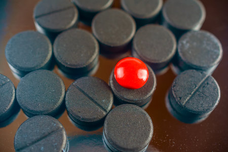Pills and red pill on a black background. Close-up.の写真素材