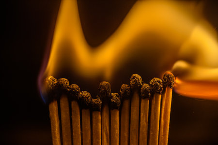 Wooden matchsticks burning on a dark background, close-upの写真素材