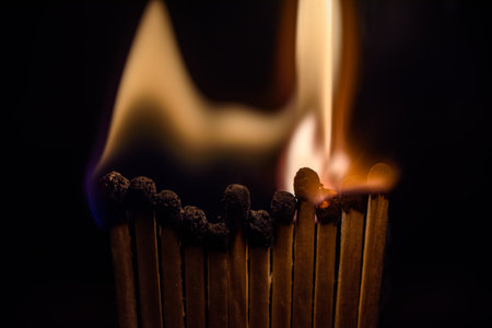 Burning matchstick on a dark background. Selective focus.