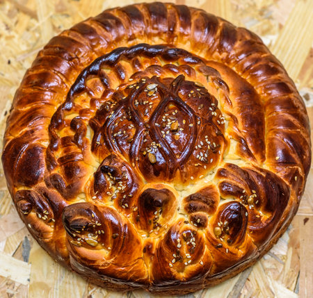 Freshly baked sweet bread with sesame seeds on a wooden backgroundの写真素材