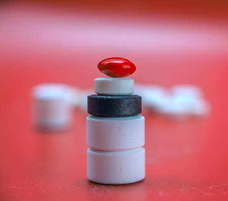 Pills and capsules on red background. Focus on foreground, shallow DOF.の写真素材