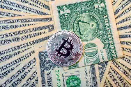 Silver bitcoin on the background of dollar bills. Cryptocurrency.の写真素材