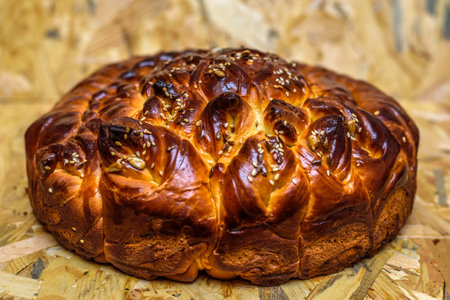 Baked loaf of bread with sesame seeds on a wooden backgroundの写真素材