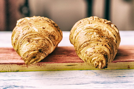 Croissant on a light wooden background. Photographed in high key.