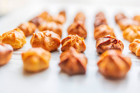 Choux pastry on a light wooden background. Photographed close-up.の写真素材