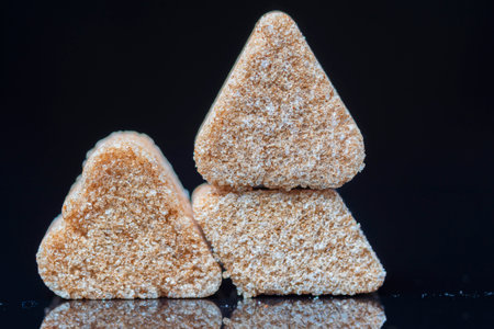 A piece of refined sugar on a black background. Photographed close-up.の写真素材
