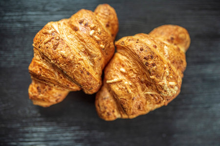 Croissant on a dark wooden background. Photographed close-up.の写真素材