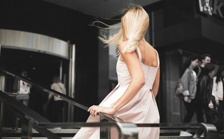 beautiful Girl without glasses on a urban background in a pink dressの写真素材