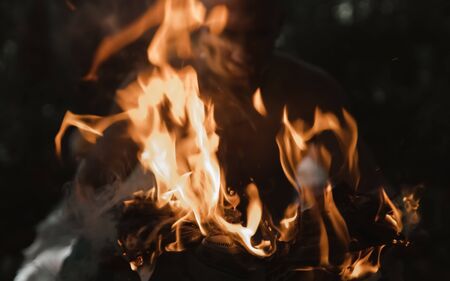 Man on fire tongues of flame On the hand in the forest