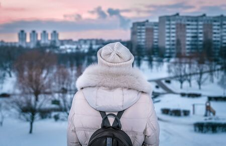 Back view of young urban traveler woman looking at cityscapeの写真素材