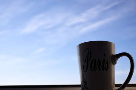 cup of tea stand on the parapet of the window against the background of the autumn panorama of the cityの写真素材