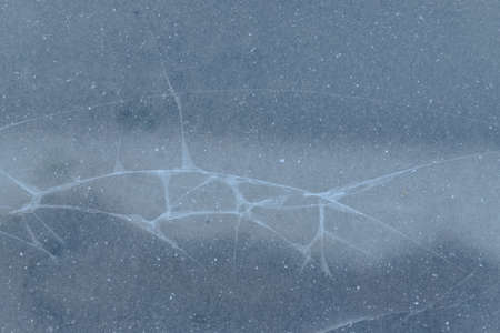 Abstract ice background with cracks on the ice surface winter