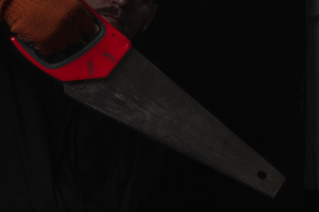 saw with a red handle in man hand isolated on white background