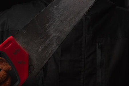 saw with a red handle in man hand isolated on white background