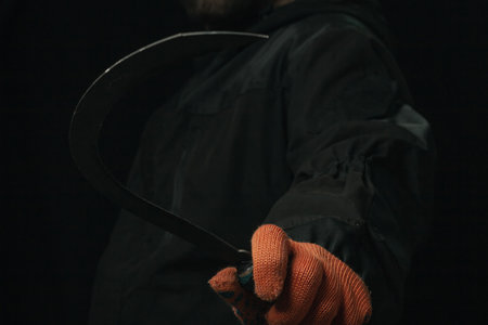 hand holding a sickle backgroundsの写真素材