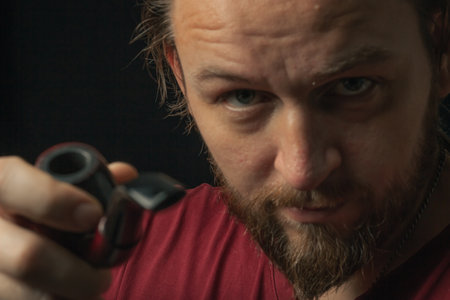 Lumberjack brutal beard muscled man in red shirt with smoking tube pipe standing on dark background