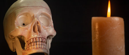 Damaged Dirty head skull and candle on black background isolated