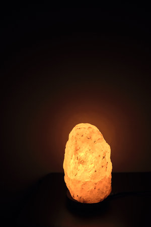 Salt lamp on the table in the room glows in the nightの写真素材