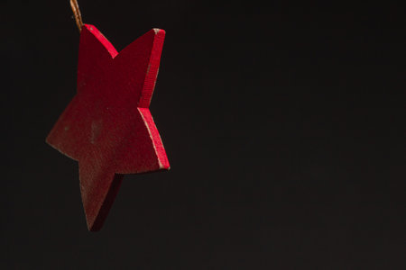 Red glitter star shaped christmas decoration isolated on black backgroundの写真素材