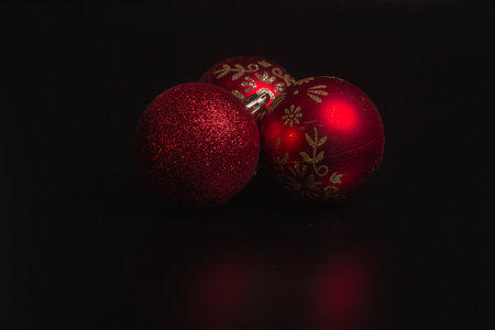 Red Christmas ball on a Christmas tree with a garland on the black backgroundの写真素材