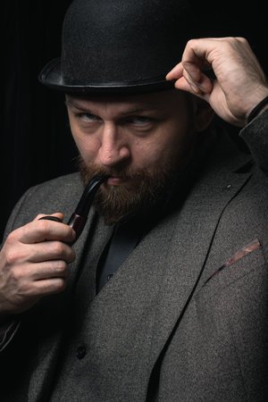 stylish man in retro outfit suit hat smoking wooden pipe cosplay england gentleman fashionable...