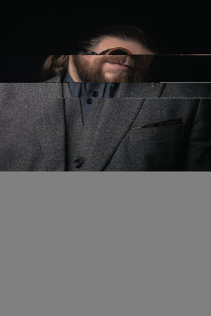 charismatic man in a classic suit and steampunk goggles on a black background stylish Portrait