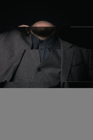 charismatic man in a classic suit and steampunk goggles on a black background stylish Portraitの写真素材