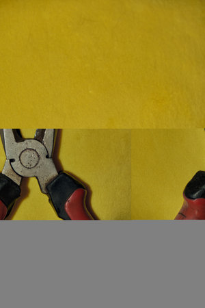 Pliers Open metal nippers with a red handle isolated on yellow backgroundの写真素材