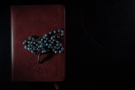 Rosary beads and crucifix cross on holy bible backgroundの写真素材
