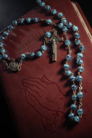 Rosary beads and crucifix cross on holy bible background