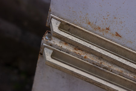 An old rusty refrigerator was thrown away on the street in sun light concrete wall on background...