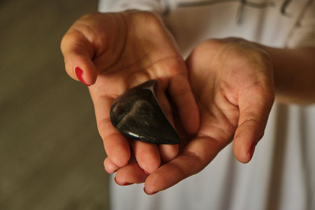 Woman Holding a different natural magic massage stones with both handsの写真素材