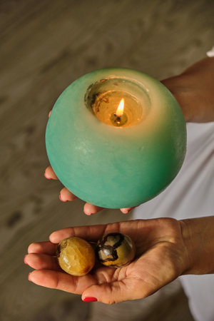 Woman holding candle in hands on casual home background, closeupの写真素材