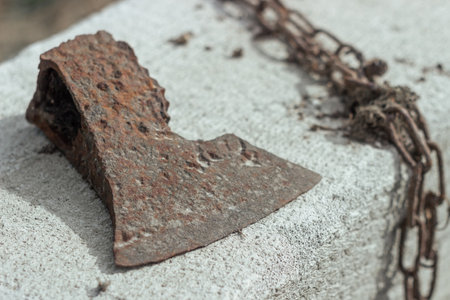 Abstract of Lumberman tools with broken rusted axe, head, chain on a gas silicate block