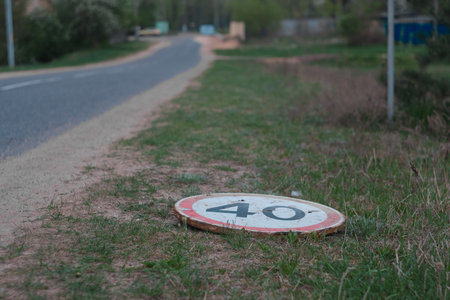 dirt road with 40 kmh speed limit and warning sign lies on the groundの写真素材