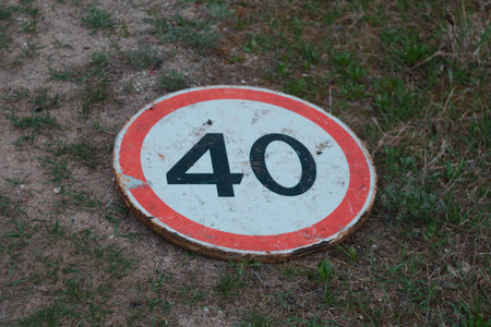 dirt road with 40 kmh speed limit and warning sign lies on the groundの写真素材