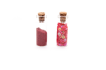 Glitter (small balls and figurines) in small glass bottles with corksの写真素材