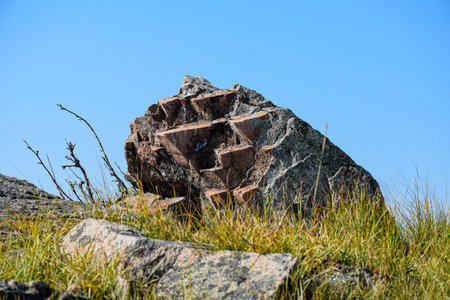 A stone in the grass against the background of the blue sky. Khakassia, Siberia, Russiaの写真素材