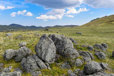 Mountain meadow with large stones on a background of blue sky. Khakassia, Siberia, Russia