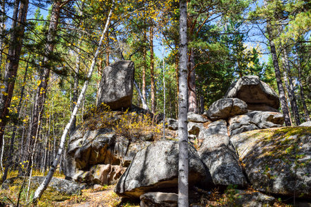 rocky cliffs in the woods in autumn with blue sky and white clouds. Khakassia, Siberia, Russia, Stone Park, Shirinsky Pillars, July Stone Parkの写真素材