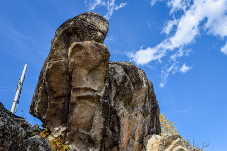 Stone sculpture on the cliff against the blue sky with white clouds. Khakassia, Siberia, Russia, Stone Park, Shirinsky Pillars, July Stone Parkの写真素材