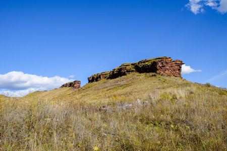 The hillside is covered with green grass against the blue sky.