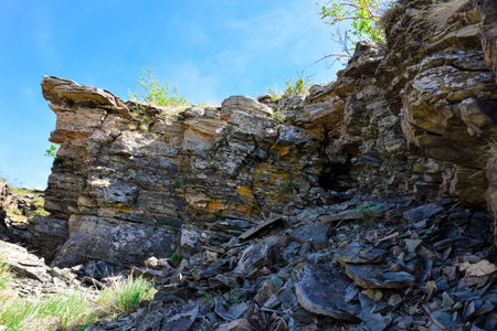 Rocky slope of the mountain against the background of a blue sky. Russia, Krasnoyarsk Territory,...