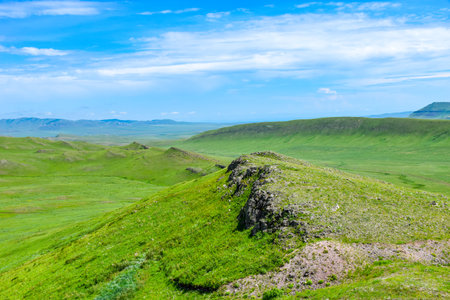 grassland under the blue sky with white clouds. Paleovolcano surroundings, Khakassia, Siberia, Russiaの写真素材