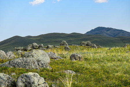 Mountain landscape with green grass, stones and blue sky in summer. Khakassia, Siberia, Russia, Sahsyrの写真素材